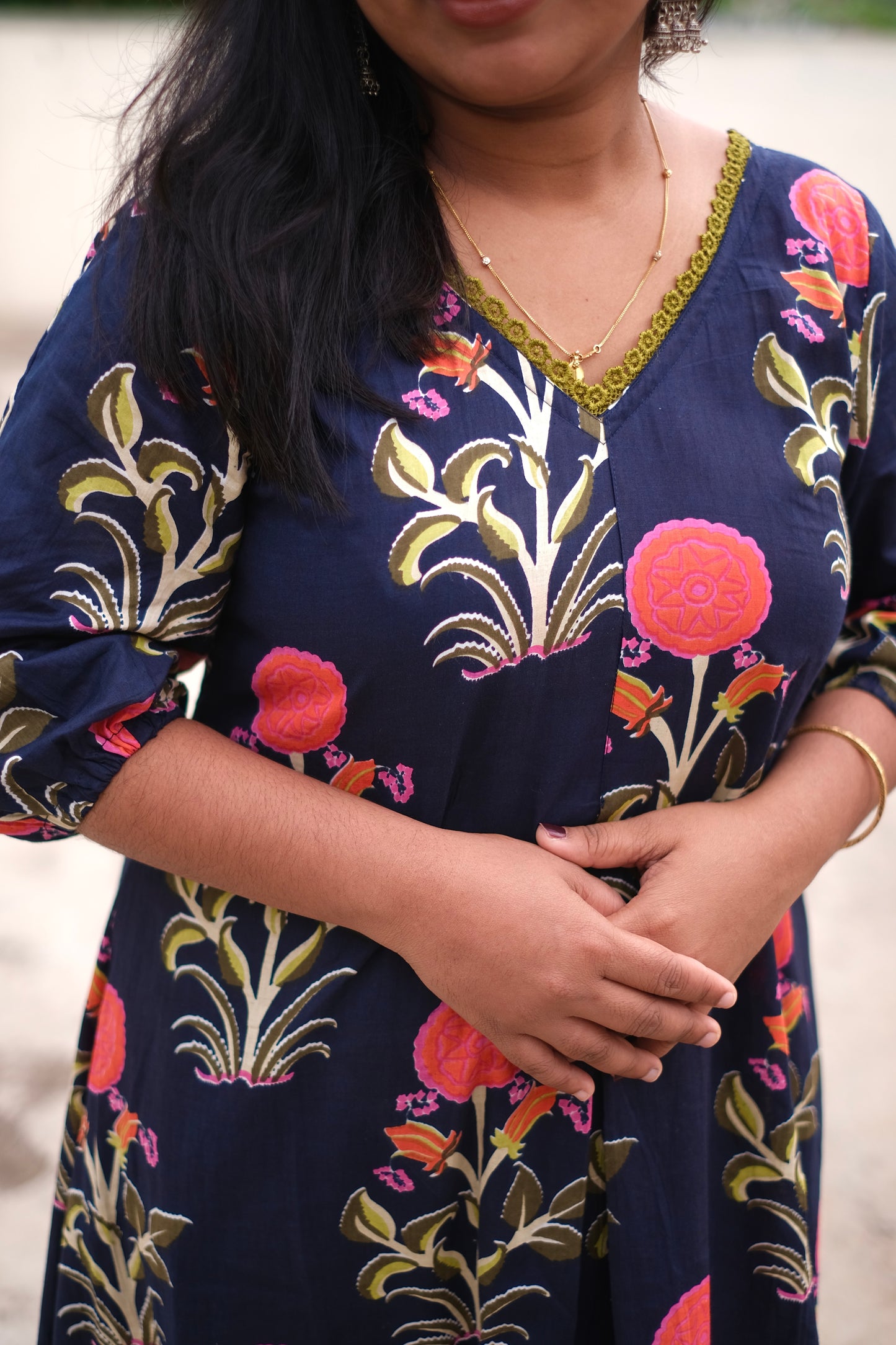 Navy blue dress with floral patterns worn by a person.